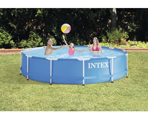 Une famille joue au ballon dans une piscine hors sol Intex dans le jardin.