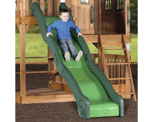 Ein Kind rutscht auf einer grünen Rutsche eines Holzspielhauses.