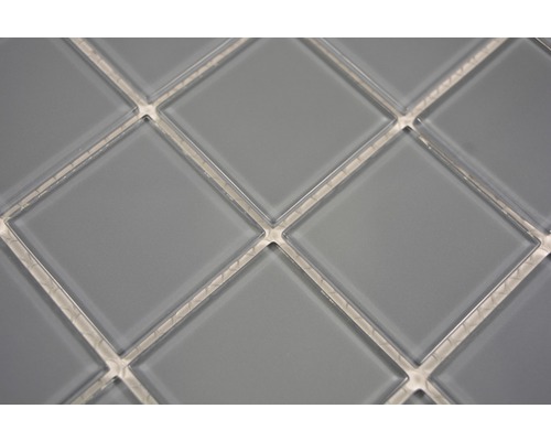 Gros plan de carreaux de mosaïque gris en forme de losange.