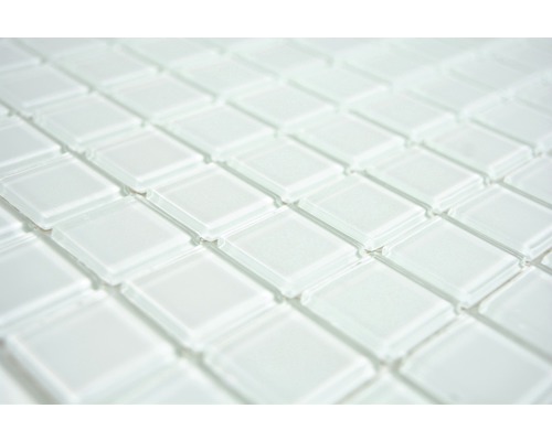 Gros plan de carreaux de mosaïque en verre blancs formant un motif répétitif.