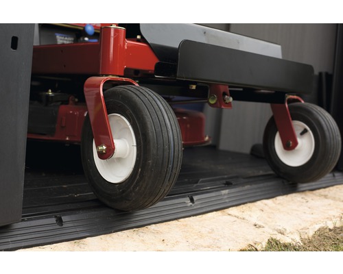 Detailaufnahme eines Rasentraktors im Unterstand, Fokus auf Räder