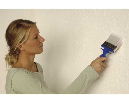 Femme peignant un mur avec un pinceau plat