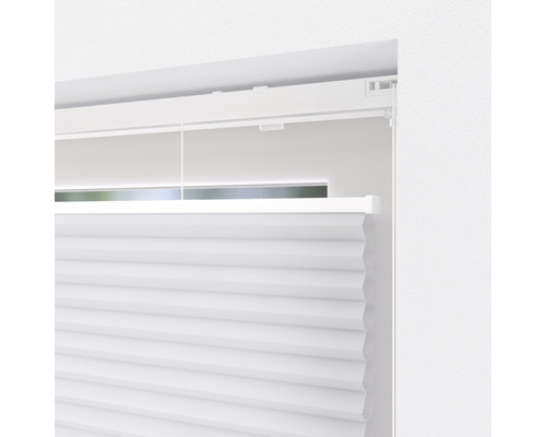 Detailansicht eines weissen Plissees am Fenster