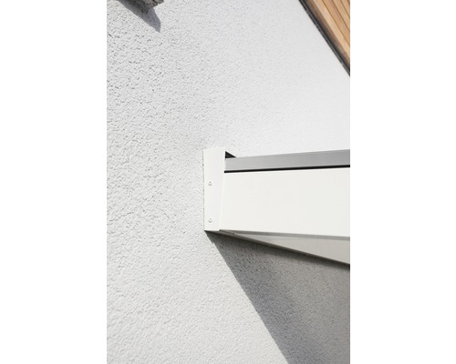 Vue détaillée d''une fixation de store banne blanche sur un mur