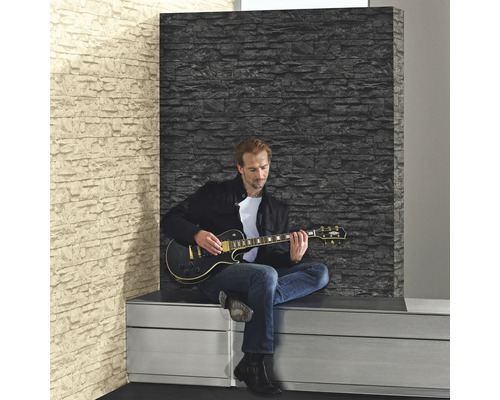 Homme jouant de la guitare devant un mur avec du papier peint aspect pierre