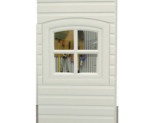 Detailansicht eines Gerätehauses mit einem Fenster, durch das Gartengeräte erkennbar sind.