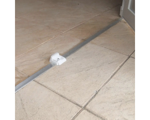 Profilé de transition en aluminium avec fixation sur sol carrelé.