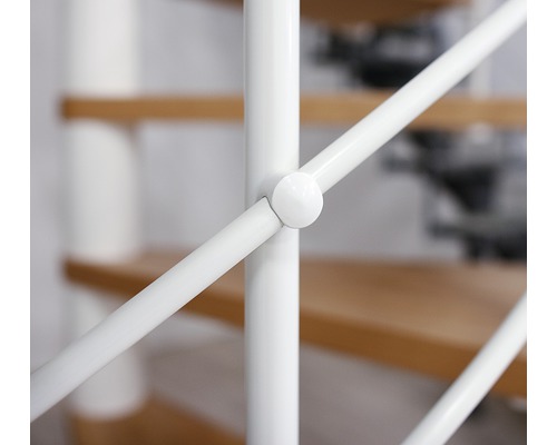 Gros plan d''une rampe d''escalier blanche avec des marches en bois en arrière-plan