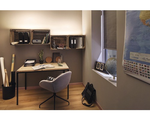 Arbeitszimmer mit Schreibtisch, Stuhl und Wandregalen aus Holzkisten