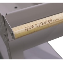 "Detailansicht eines Kräuterwagens mit Holzgriff und der Aufschrift ""grow it yourself by herstera""."