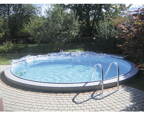Piscine ronde avec couverture et échelle dans le jardin