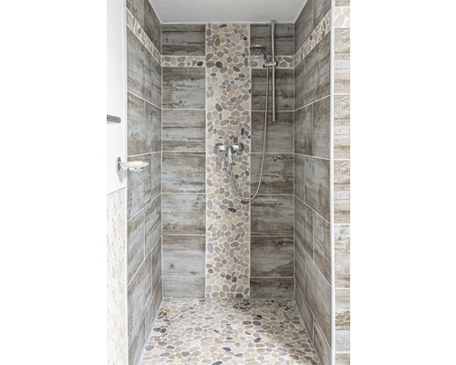 Cabine de douche carrelée avec des carreaux imitation bois et des galets
