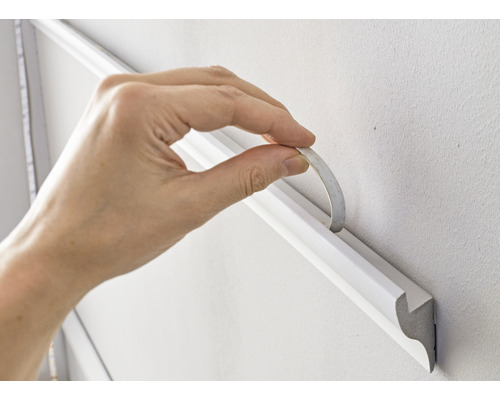 Fixation d''une moulure décorative au mur avec du ruban adhésif