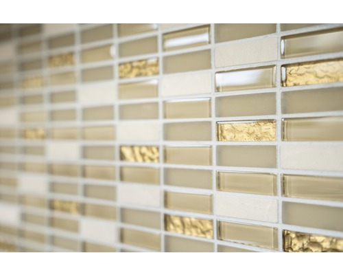 Gros plan d''un mur avec des carreaux de mosaïque dans les tons beige, or et crème