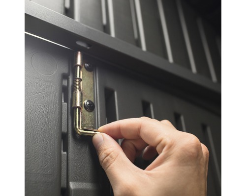 Detailansicht einer Hand, die einen Metallriegel an einem grauen Kunststoffschrank befestigt.