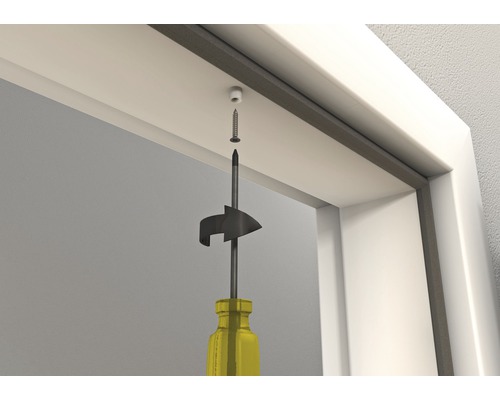 Montage d''un ferme-porte avec un tournevis sur le cadre de la porte