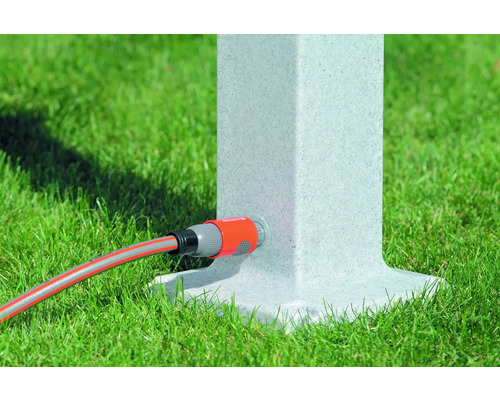 Gartenschlauch an Wasserzapfsäule auf Rasen angeschlossen