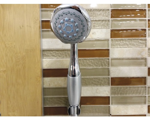 Douchette à main en métal sur fond de salle de bain.