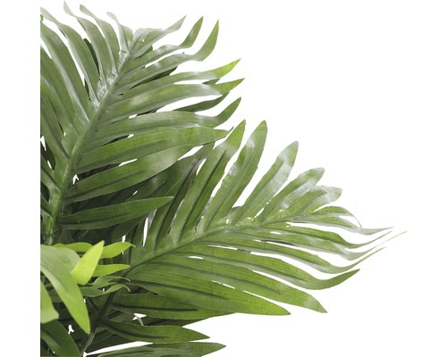 Gros plan sur un palmier artificiel avec des feuilles vertes comme décoration