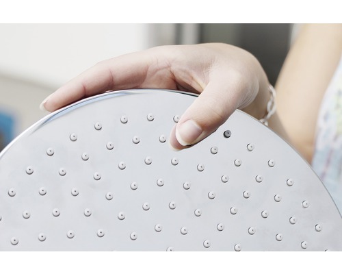 Main tenant une pomme de douche avec tête de douche