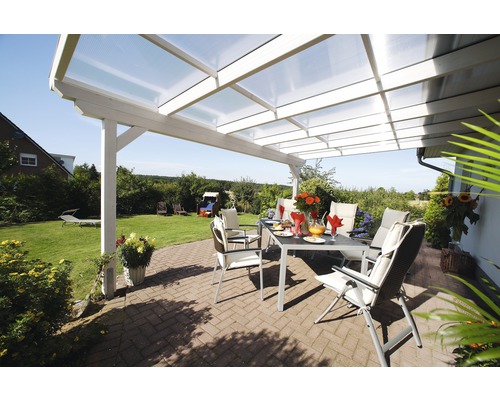 Terrasse couverte avec table, chaises et vue sur le jardin