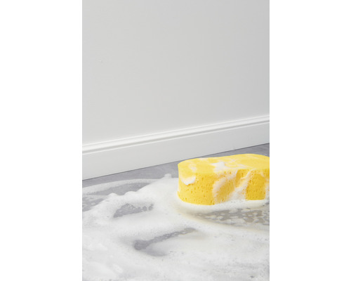 Gelber Putzschwamm mit Schaum auf einem Boden