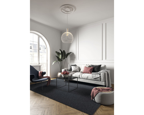 Wohnzimmer mit Sofa, Sessel, Couchtisch, Hängelampe und Teppich auf Parkettboden