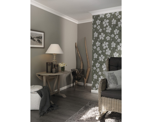 Séjour avec parquet, papier peint à décor floral et meubles en bois.