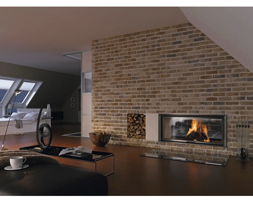 Salon avec mur en maçonnerie, cheminée, réserve de bois et meubles de salon.