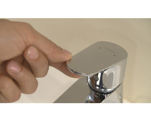 Hand betätigt Armatur von Hansgrohe im Badezimmer