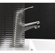 Dekorglas mit linearem Muster neben einem Waschbecken und einer Armatur