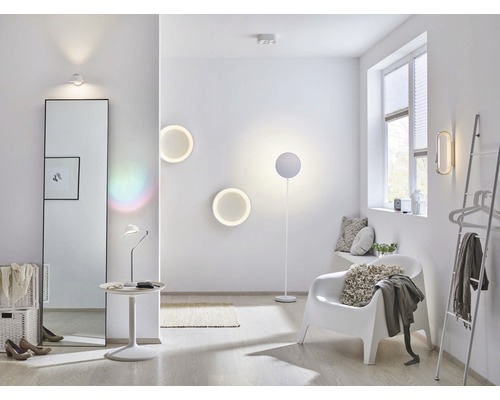 Helles Zimmer mit Spiegel, Stuhl, Stehlampe und Wandleuchten