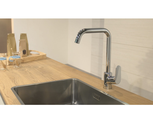 Scène de cuisine avec évier, robinet et plan de travail en bois