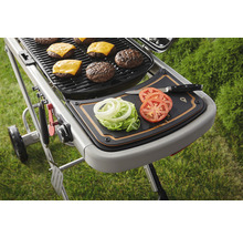Grill mit Burgern, Käse, Tomaten, Salat und Zwiebeln auf einem Schneidebrett