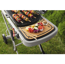 Grill mit Gemüsespießen und Schneidebrett für die Zubereitung weiterer Spieße