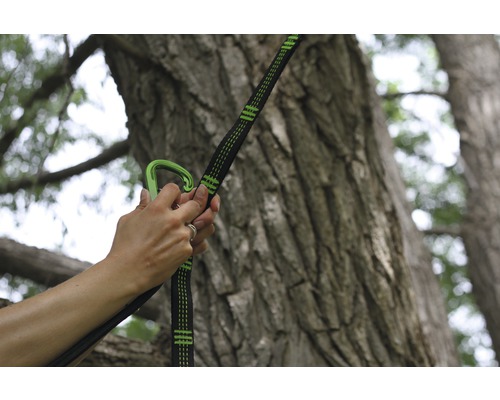 Femme fixant un hamac à un arbre avec un mousqueton et une sangle d''arbre