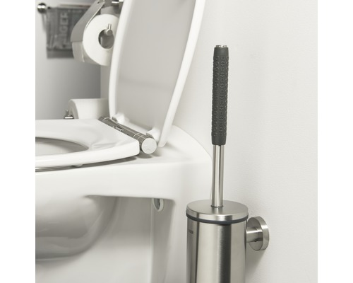 Brosse de toilette en acier inoxydable à côté de toilettes