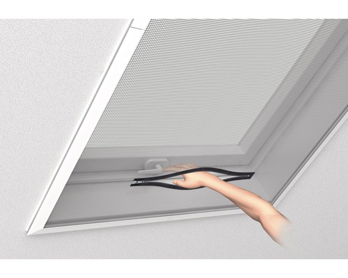 Une fenêtre de toit avec moustiquaire est actionnée par une main