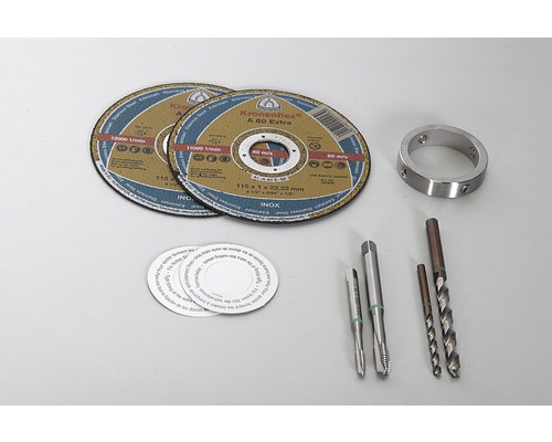Zwei Trennscheiben, ein Metallring, zwei Gewindebohrer, Aufkleber und zwei Bohrer liegen auf einer Oberfläche.
