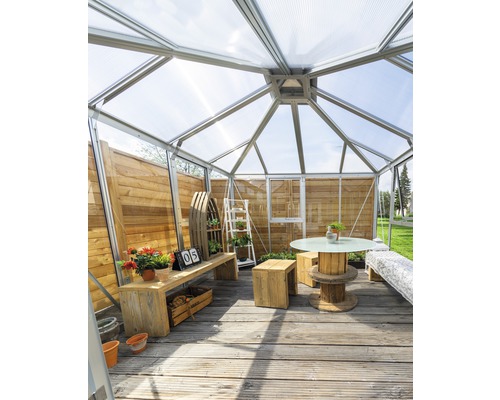 Serre avec mobilier en bois et décoration végétale sur terrasse en bois