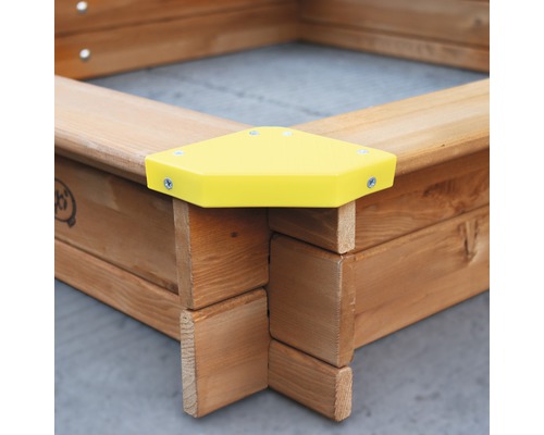 Vue détaillée d''un bac à sable en bois avec protection d''angle jaune
