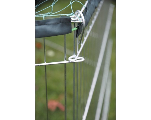 Vue détaillée d''une clôture métallique avec couverture en filet et pinces de fixation.