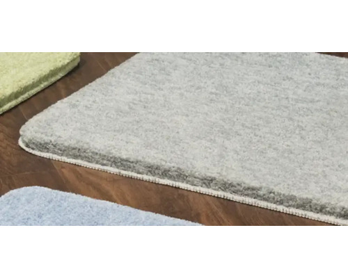 Vue détaillée de différents tapis de bain sur plancher en bois