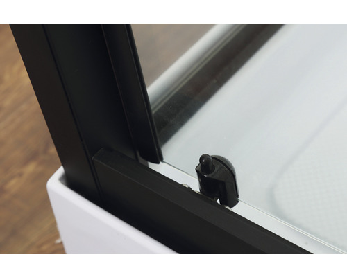 Detailansicht einer Duschkabine mit schwarzem Rahmen und Türschloss