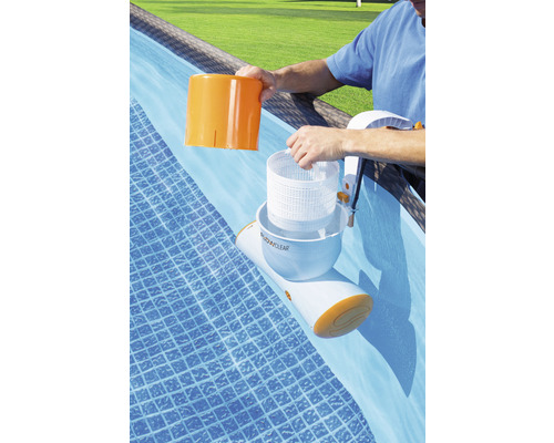 Un homme entretient un skimmer de surface Flowclear dans une piscine.