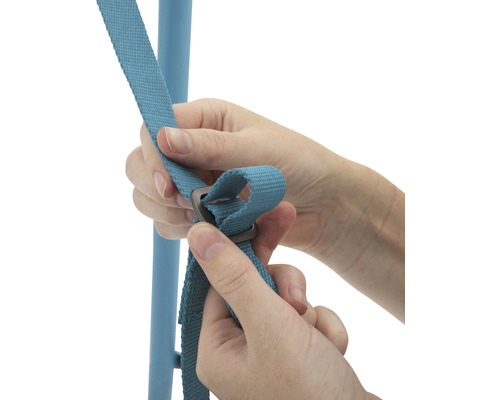 Des mains fixent une sangle bleue avec une boucle métallique à un cadre bleu