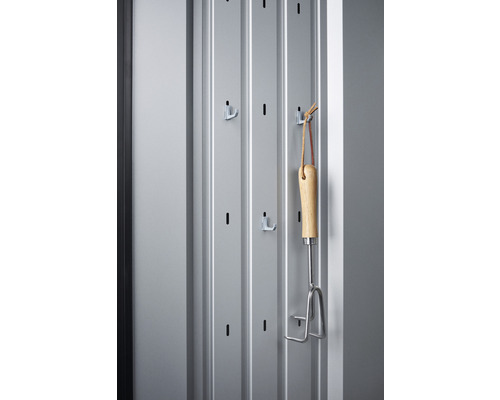 Support à outils avec outil de jardinage sur un mur gris