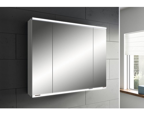 Spiegelschrank mit drei Türen und Beleuchtung im Badezimmer.