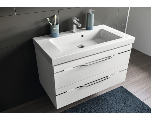 Badezimmer mit Waschbeckenunterschrank, Armatur, Seifenspender, Zahnputzbecher und Teppich