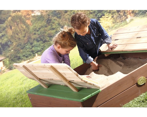 Deux enfants jouent dans un bac à sable en bois avec couvercle